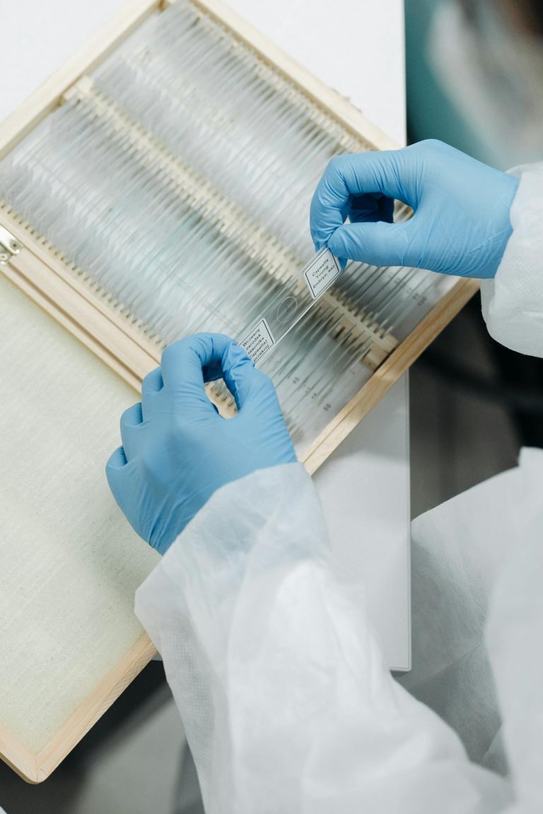 Close-up of a scientist wearing gloves and handling lab slides, ensuring precise research.